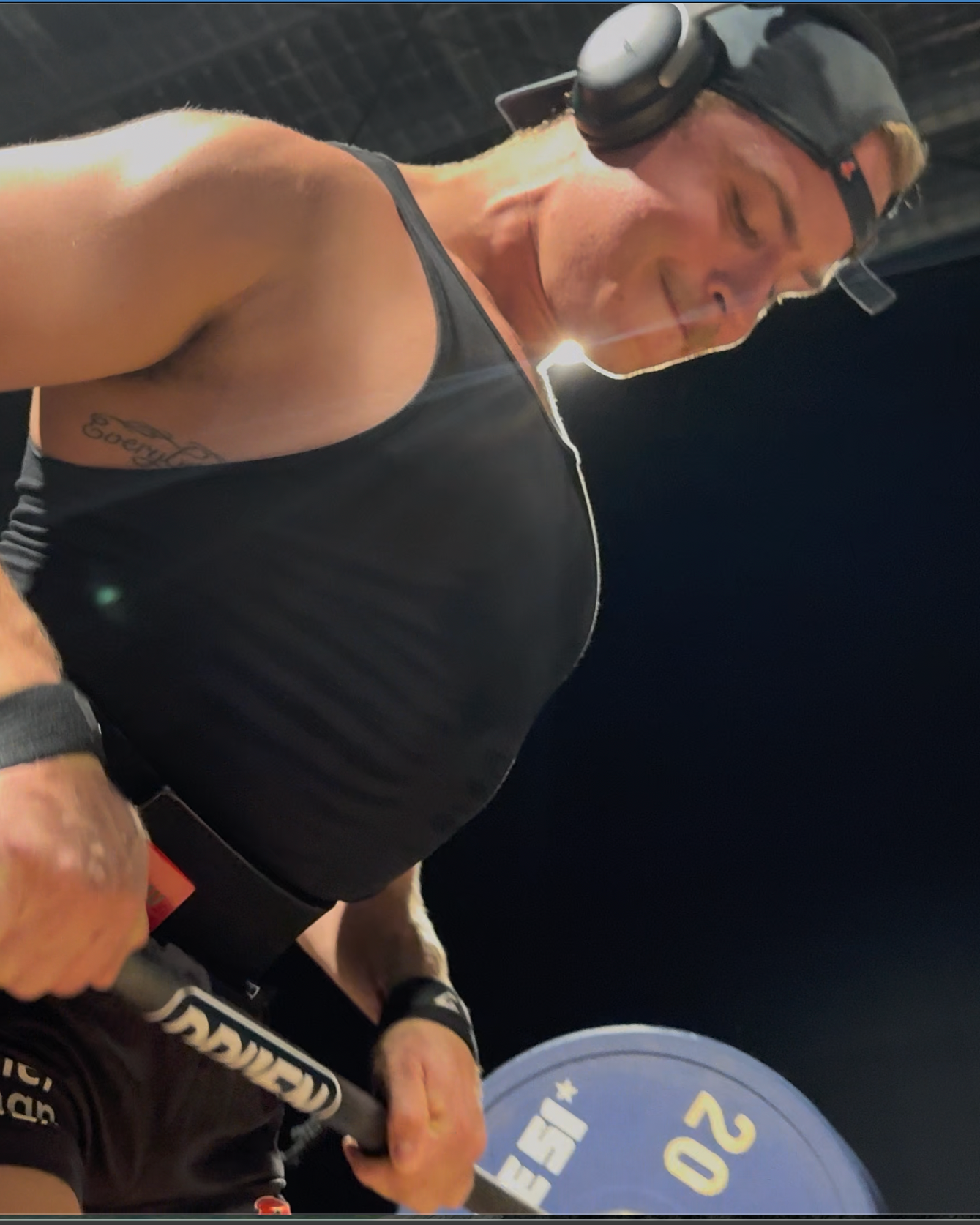 DRIVEN Athletica Member lifting weights with a barbell on a dark background